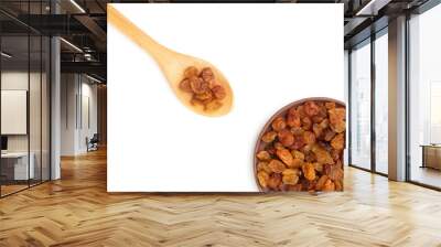 Raisins in clay plate and wooden spoon on white. Healthy eating concept Wall mural