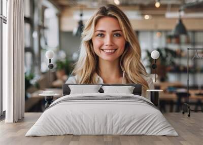 Business blonde woman standing competently and smiling in open plan office Wall mural