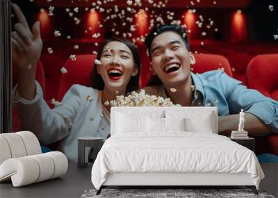 Happy trip of asian couple sweet sit togather on red seat and looking movie in cinema with fun a popcorn on hand, people relax and holiday activity on a weekend Wall mural