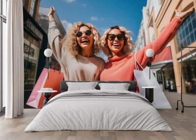 Two girlfriends walking on the street with bags while shopping. two happy girlfriends. shopping concept Wall mural