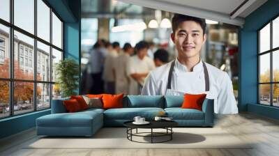 Closeup photo portrait of a handsome young asian chef cook with white uniform standing. guests eating in the restaurant. blurry food restaurant kitchen in the background Wall mural