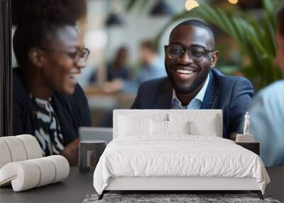 Happy black financial advisor using touchpad with his clients during meeting in office Wall mural