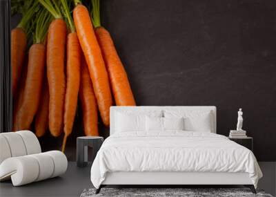 Bunch of raw carrots on dark background. Wall mural