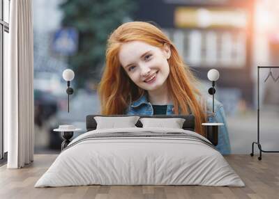 candid outdoor portrait of pretty smiling young girl with long red hair, morning sunrise light Wall mural