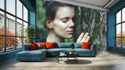 Young woman touching tree trunk, spiritual healing, love nature Wall mural