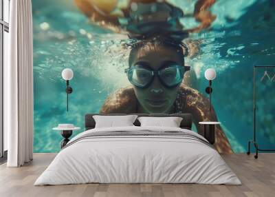 underwater selfie picture of a female swimmer in swimming suit and goggles training in swimming pool Wall mural