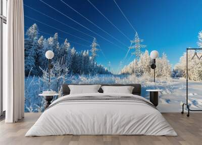 The overhead electric line over blue sky.  Electrical wires of power line or electrical transmission line covered by snow in the winter forest. Wall mural