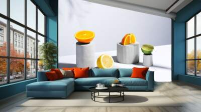 Citrus still life concept with lemon,lime and orange on gray stands and podiums over white background, horizontal Wall mural