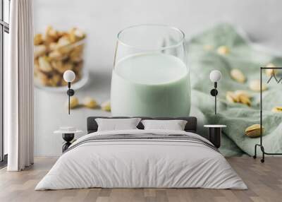 pistachio milk in the glass on the concrete gray background, horizontal orientation Wall mural