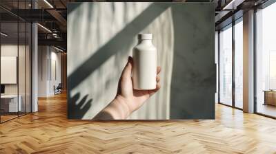 White bottle held in hand against sunlight, mockup, copy space concept Wall mural