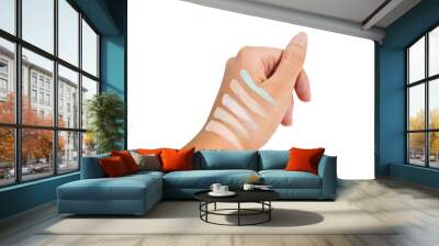 A woman's hand is trying to apply a cosmetic product color corrector or concealer on her hand, isolated on white background and close up shot. Wall mural