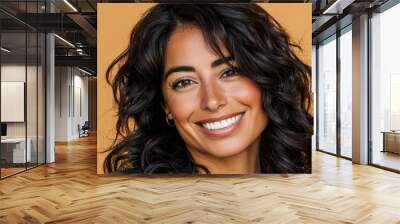 This is a portrait of a beautiful long-haired young eastern woman posing on a beige studio background with a smile on her face, with copy space below. Wall mural