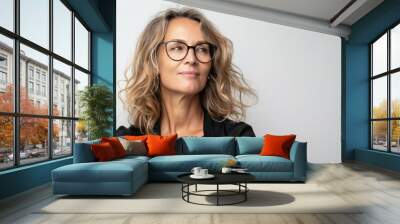 This stunning businesswoman is a middle-aged woman who wears eyeglasses and stands over an isolated white background, looking to the side, in a relaxed profile pose with a smile that is both natural Wall mural