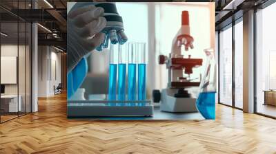 Using microscope reagent over glass equipment to work on biochemistry laboratory research, scientist or medical in lab coat holding test tube with drop of color liquid over glass equipment. Wall mural