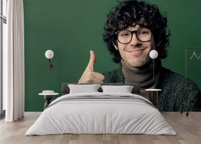 Young attractive man thumbs up in approval wearing stylish brown clothes isolated on khaki-colored background Wall mural