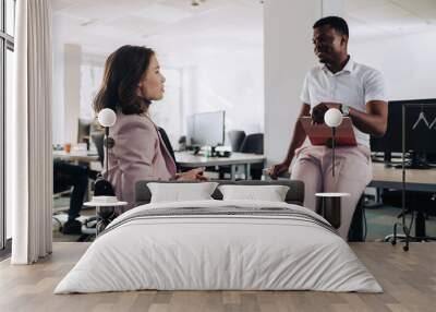 A businesswoman with disability is discussing project with a colleague. Wall mural