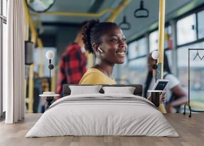 African american woman riding a bus and using a smartphone Wall mural