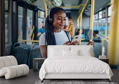 African american woman using smartphone while riding a bus Wall mural