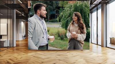 Business people talking and holding coffee outside Wall mural