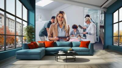 Businesswoman posing and smiling during a meeting in an office Wall mural