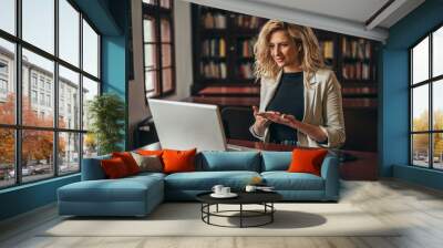 Businesswoman using a laptop for an online meeting while in the office Wall mural