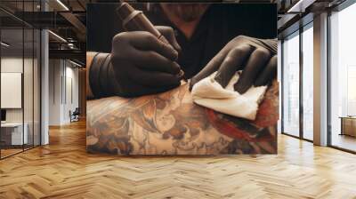 Close up tattoo machine. Tattooing. Man creating picture on his back by a professional tattoo artist. Wall mural