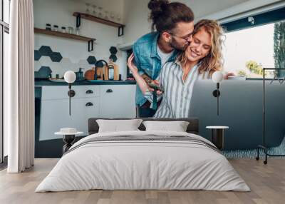 Couple working from home and spending time together in the kitchen Wall mural