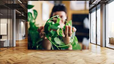 Fashionable young woman taking care of her house plants Wall mural