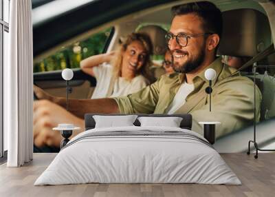 Father driving a car while the whole family is going on a weekend trip away Wall mural