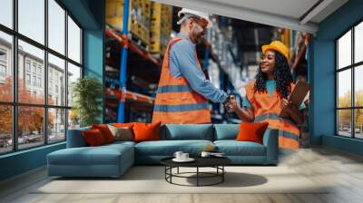 Handshake seals collaboration between two diverse warehouse workers. Wall mural