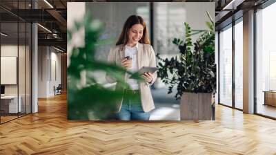 Happy smart causal businessman with tablet at office drinking coffee. Wall mural