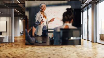 Senior female leader having presentation in front of her team at office Wall mural