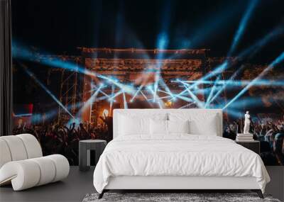 Silhouettes of concert crowd in front of bright stage lights on a music festival Wall mural