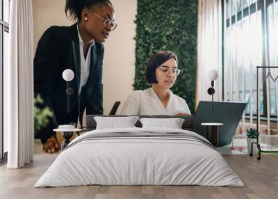 Two multiracial businesswoman working together in an open space office Wall mural