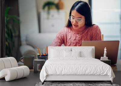 Vietnamese Asian woman using laptop while working at home Wall mural