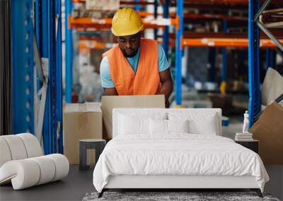 Warehouse worker picking up cardboard box from shelf Wall mural