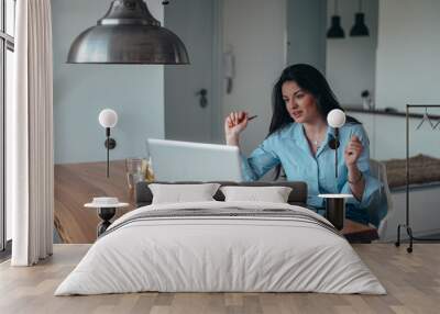 Young beautiful businesswoman in her office using a laptop Wall mural