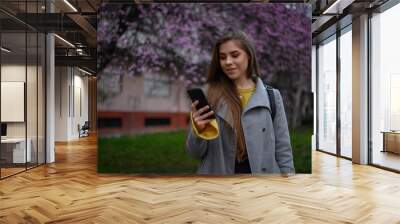 Young beautiful woman using a smartphone Wall mural