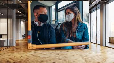 Young couple wearing protective masks riding a bus Wall mural