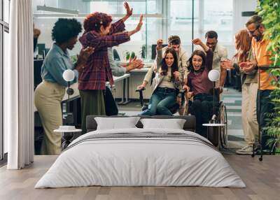 Young diverse business people racing in an office chair race at work Wall mural