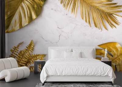 Creative layout made of golden tropical leaves and palms on white marble texture background. Minimal summer exotic concept with copy space. Border arrangement background. Wall mural