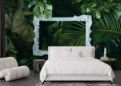 Creative layout made of tropical leaves with vintage frame. Flat lay. Nature concept. Wall mural