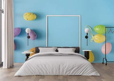 Easter layout made with colorful Easter eggs and pastel blue background. Minimal nature background. Spring holidays concept. Creative copy space. Flat lay. Wall mural