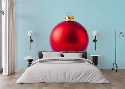 Red Christmas bauble decoration on blue background. Minimal Christmas concept. Wall mural