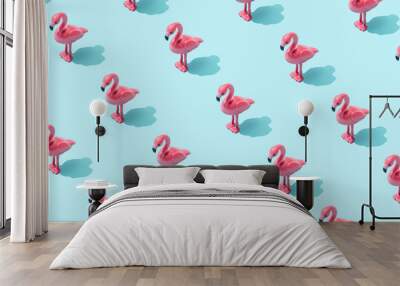 Trendy sunlight Summer pattern made with pink flamingo toy on bright light blue background. Minimal summer concept. Wall mural