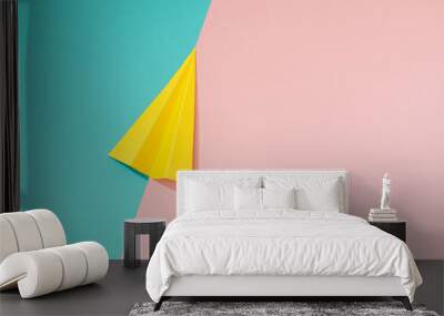 Yellow paper airplane on pastel pink and blue background. Minimal flat lay school concept. Wall mural