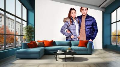 Fashion shot. Couple of young people in winter clothes posing at studio. Autumn and winter clothes. Wall mural