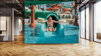 Father playing with his daughter in swimming pool. Funny family weekend. Father and daughter enjoy time together in water park.  Wall mural