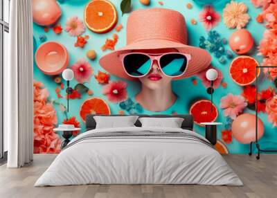 female head in hat and glasses peeks out through blue background surrounded by flowers and fruits. Wall mural