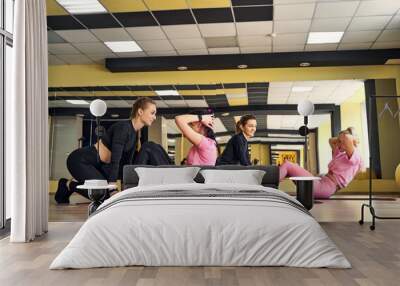 girl in the gym doing exercises for the press, teamwork Wall mural